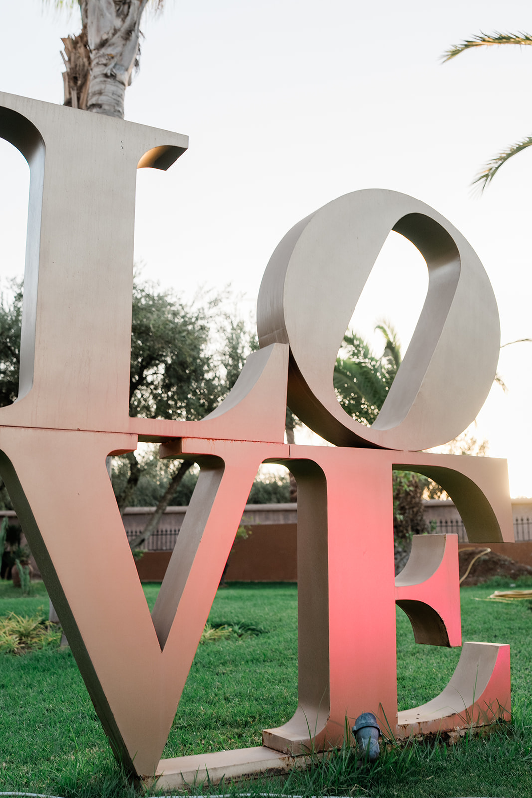 Sculpture lumineuse LOVE installée dans le jardin en fin de journée